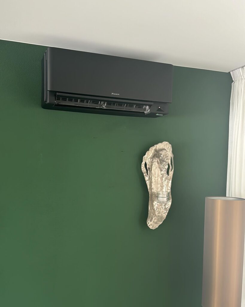 zwarte airco groene muur